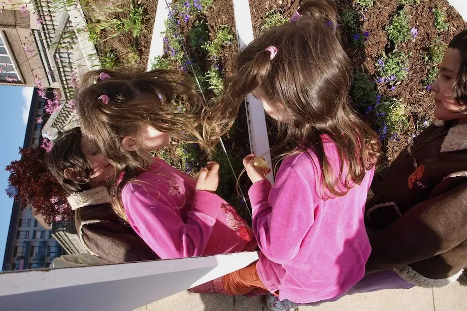 Niña jugando con los espejos del jardín